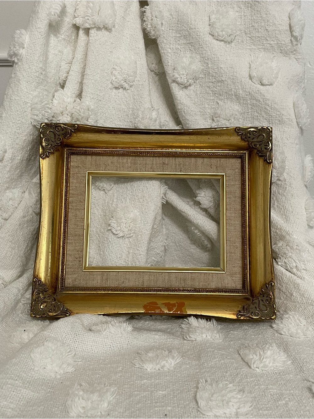 Vintage gold ornate picture frame with beige fabric matting